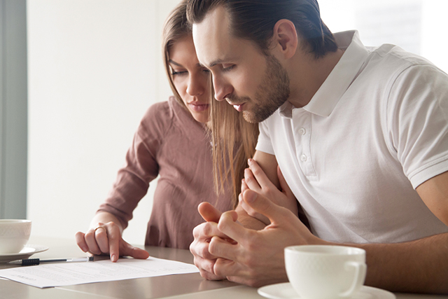 Young couple working out their financial goals at home with a coffee