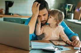 Father with daughter at computer worrying about expenses over the holiday period