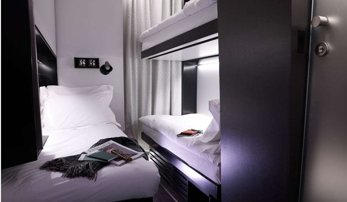 Micro hotel room with bunk beds with built in lighting, constructed from shipping containers