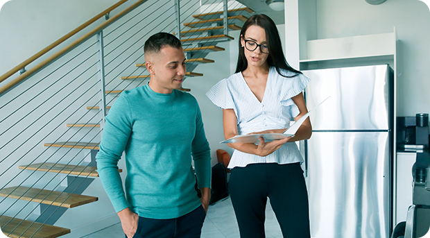 Two people look over documents during a home inspection.